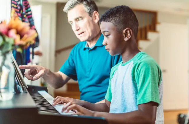 Foster dad teaching foster son how to play piano 
