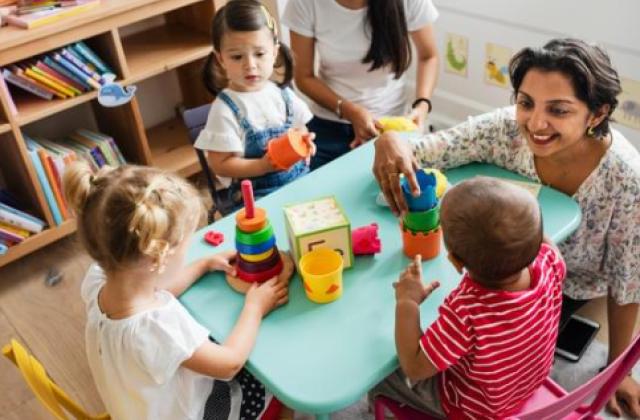 daycare women playing blocks with children
