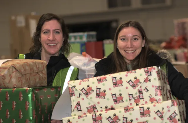 Employees holding Christmas presents
