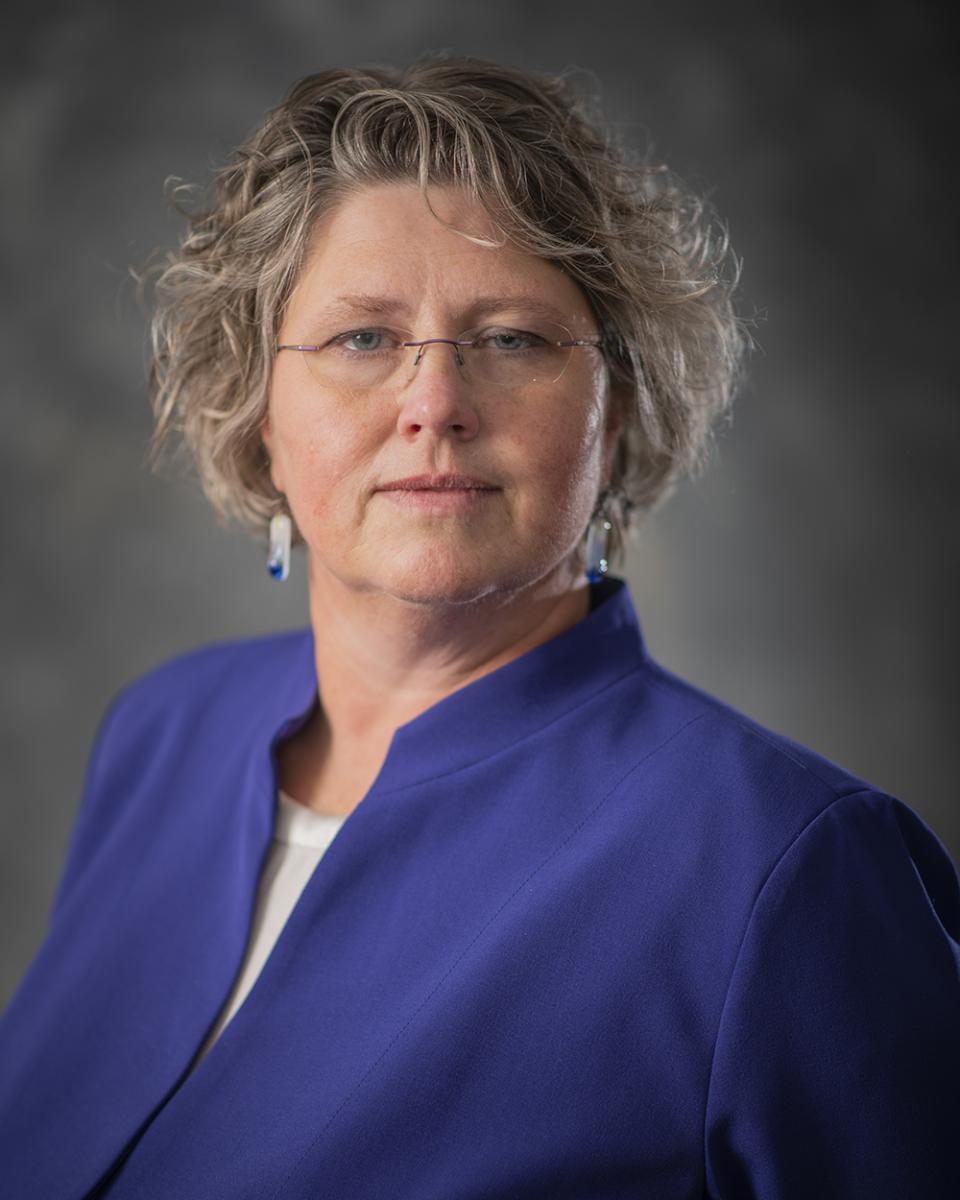 Headshot of Heidi Welsch, County Administrator, a white woman wearing a dark purple blazer and glasses