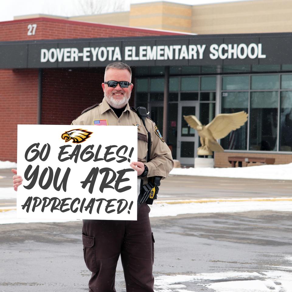 Deputy Todd Peterson holding a thank you sign for Dover Eyota Schools