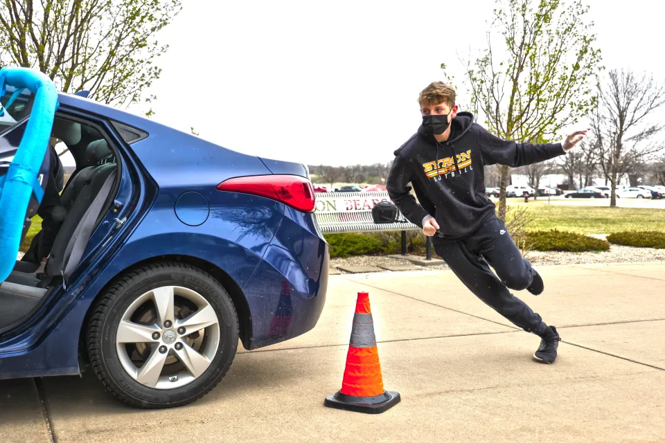 Student running around car as a part of the seat belt challenge