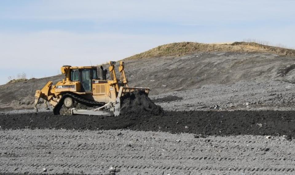 A bulldozer pushes ash at the Kalmar Landfill