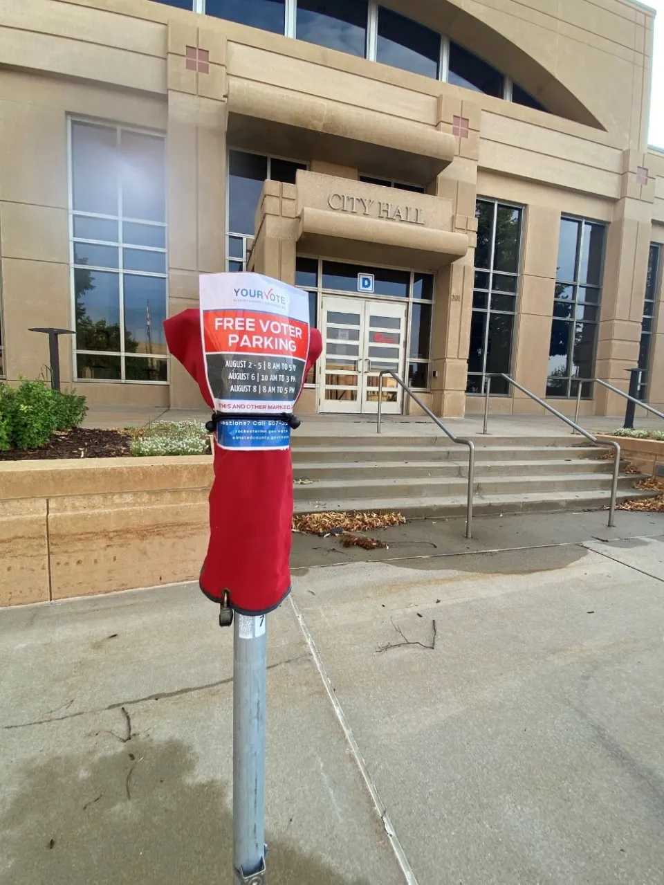 Covered parking meter outside Rochester City Hall that says, "Free voter parking."