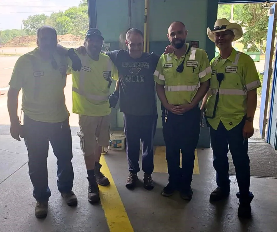 Customer Ryan Zimmer stands between the employees who helped him.