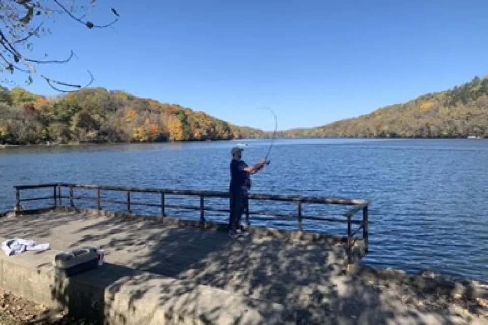 a boy fishing off a pier