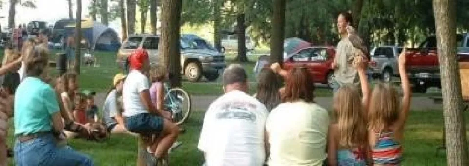 a parks naturalist holding a bird and talking to a group of people