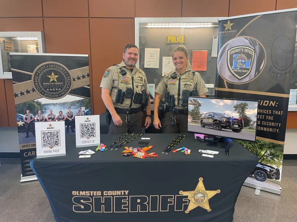 Members of the Sheriff's Office stand behind a table at a career fair