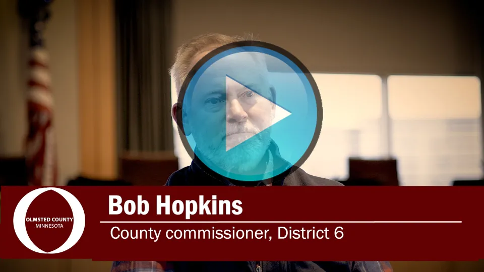 Bob Hopkins with video play button overlay