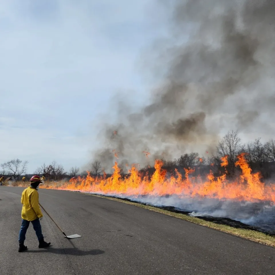 STS member standing in front of a controlled burn 