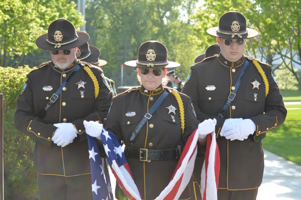 Sheriff's Office Honor Guard members holding a flag at memorial program