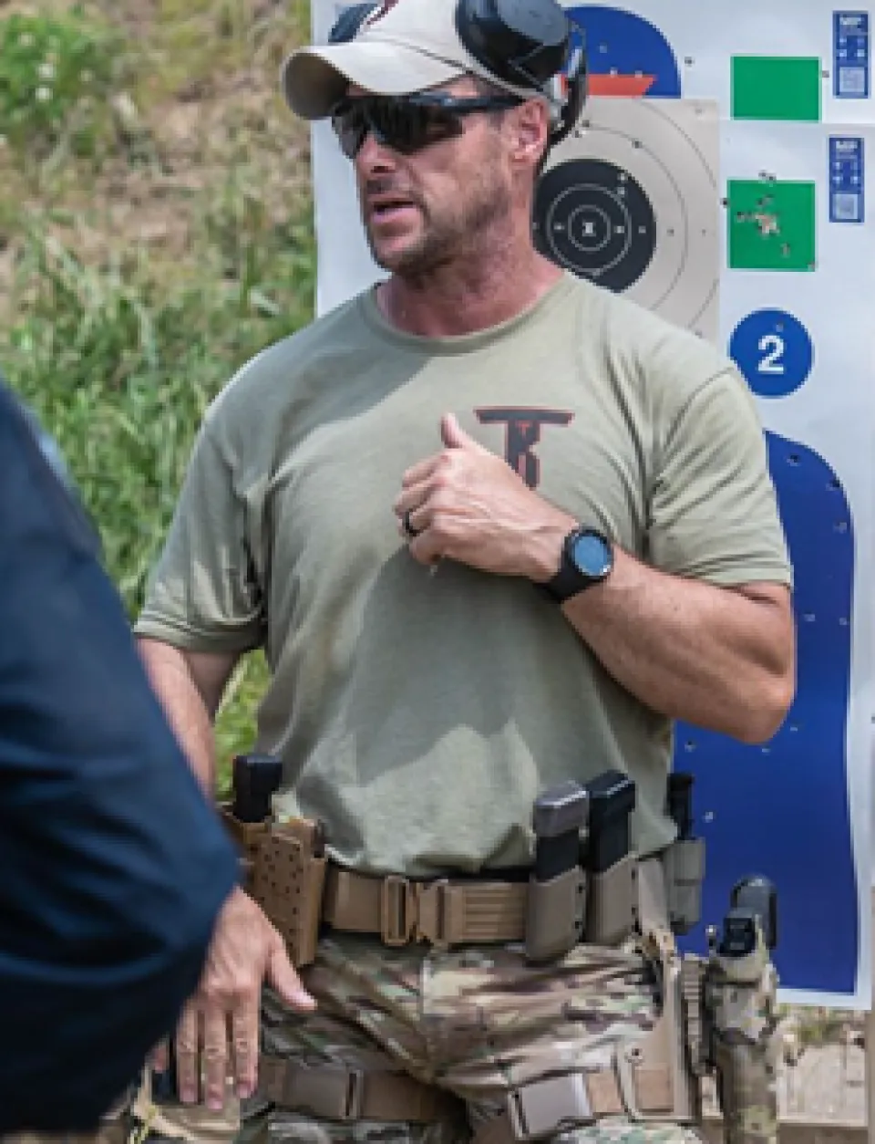 Law enforcement officer instructing course on firearms range