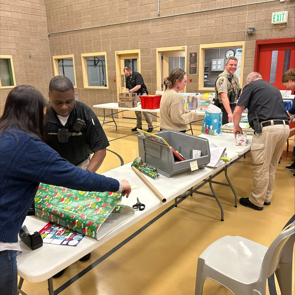 People wrapping presents for detainees inside the Adult Detention Center