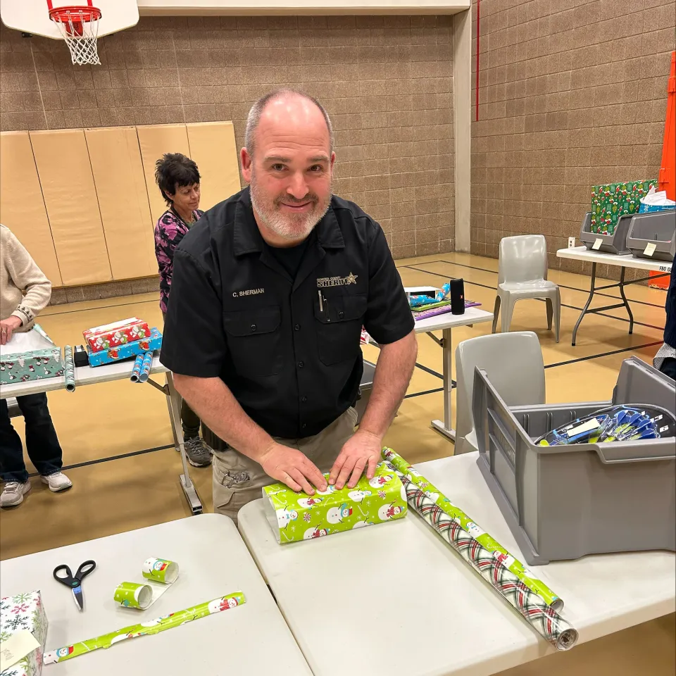 People wrapping presents for detainees inside the Adult Detention Center