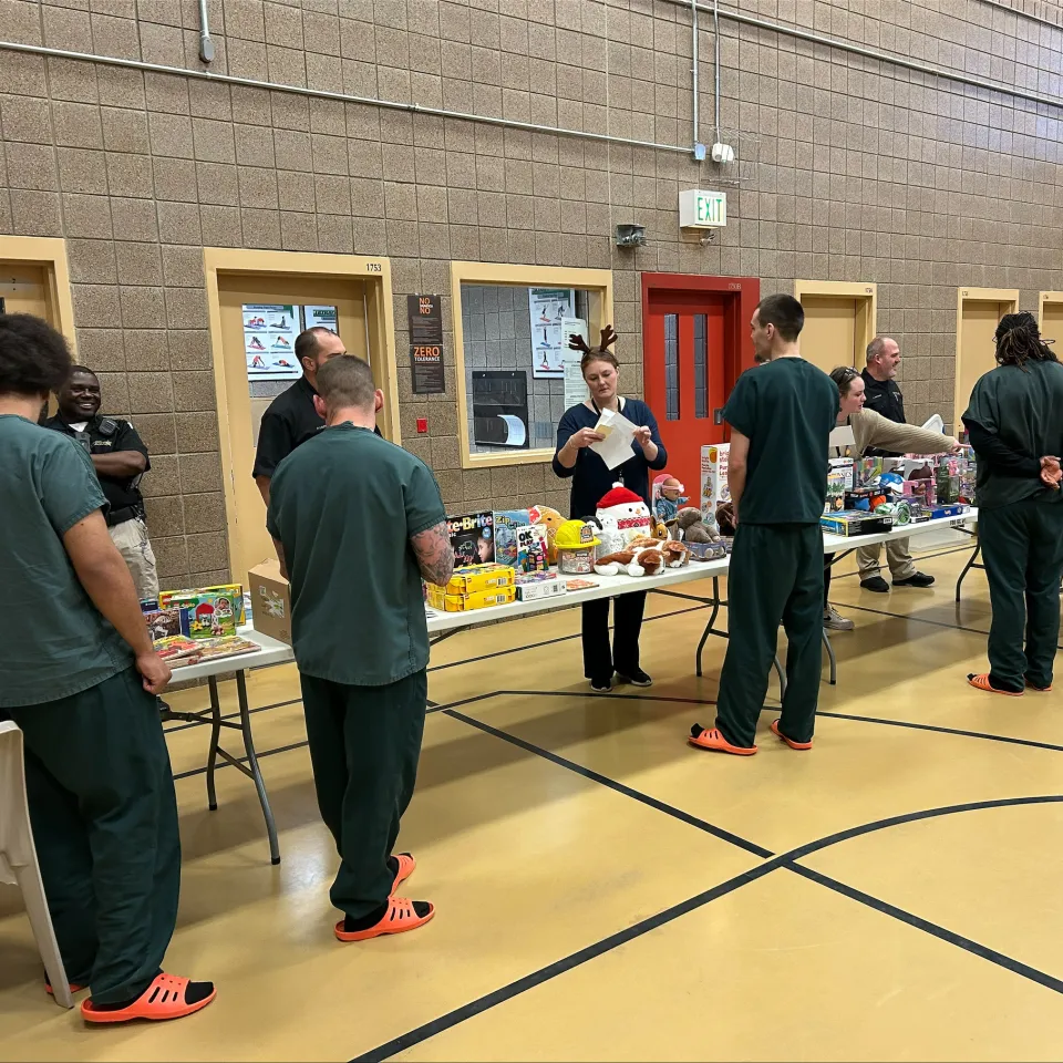 People wrapping presents for detainees inside the Adult Detention Center