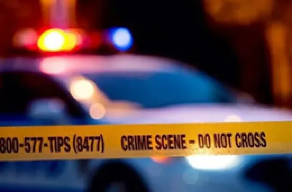 Police tape in front of a squad car