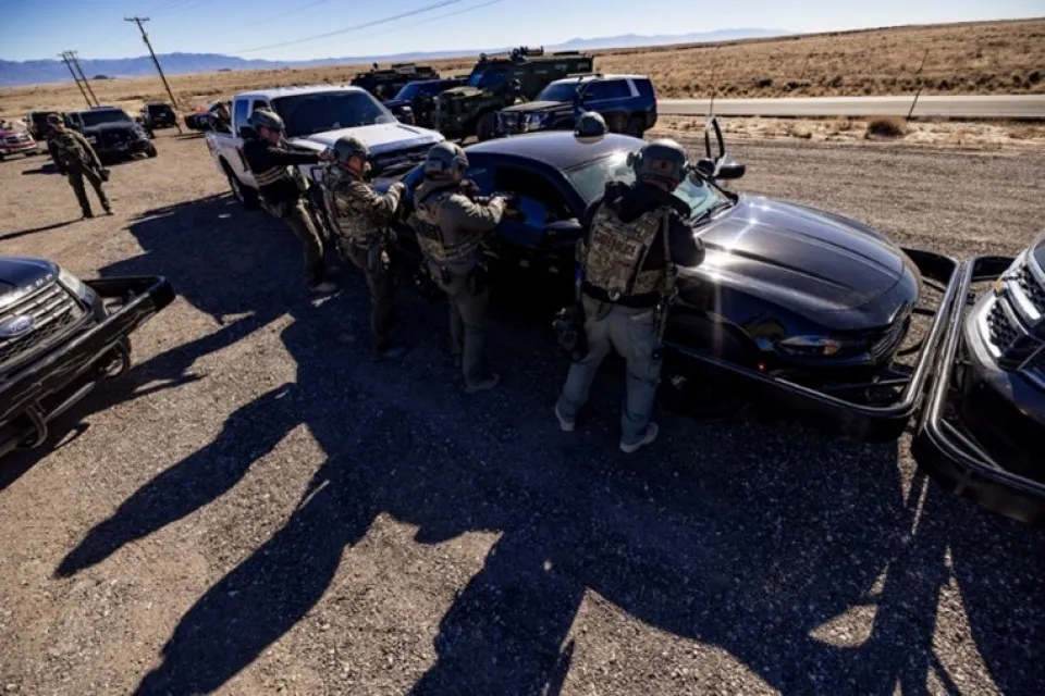 Law enforcement students stand around a vehicle