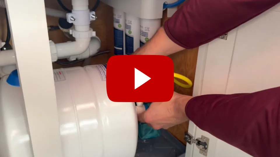 Hands working under sink with Reverse Osmosis machine with YouTube play button icon overlayed