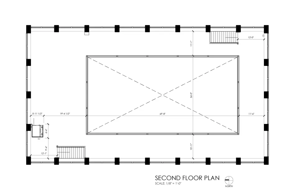 Second floor plan featuring an open perimeter layout surrounding a large rectangular central opening that overlooks the floor below. The space functions as a balcony or mezzanine with circulation around all sides. A staircase connects in the northeast corner, with additional access in the southwest area and windows lining the exterior walls.