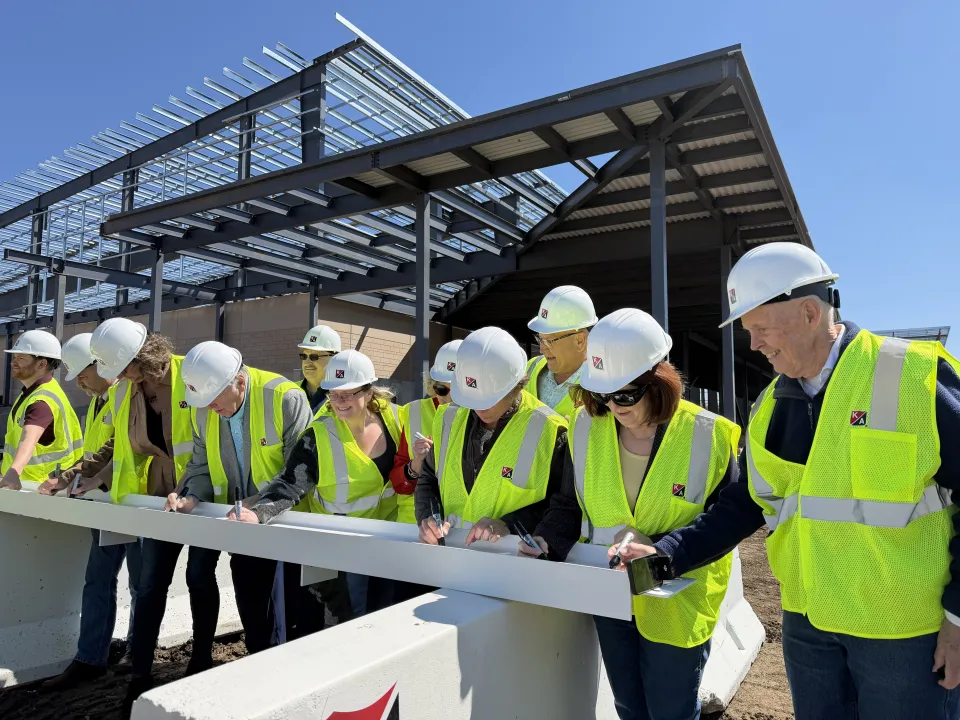 Olmsted County board and local legislator signing beam