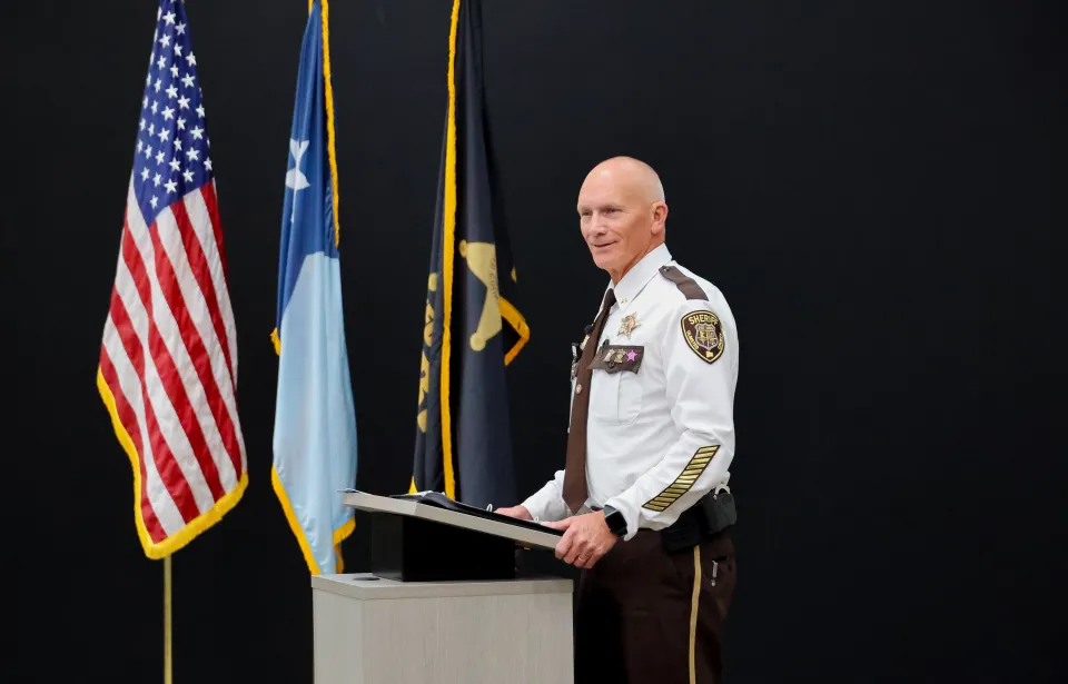 Sheriff Torgerson stands on stage welcoming those in attendance.
