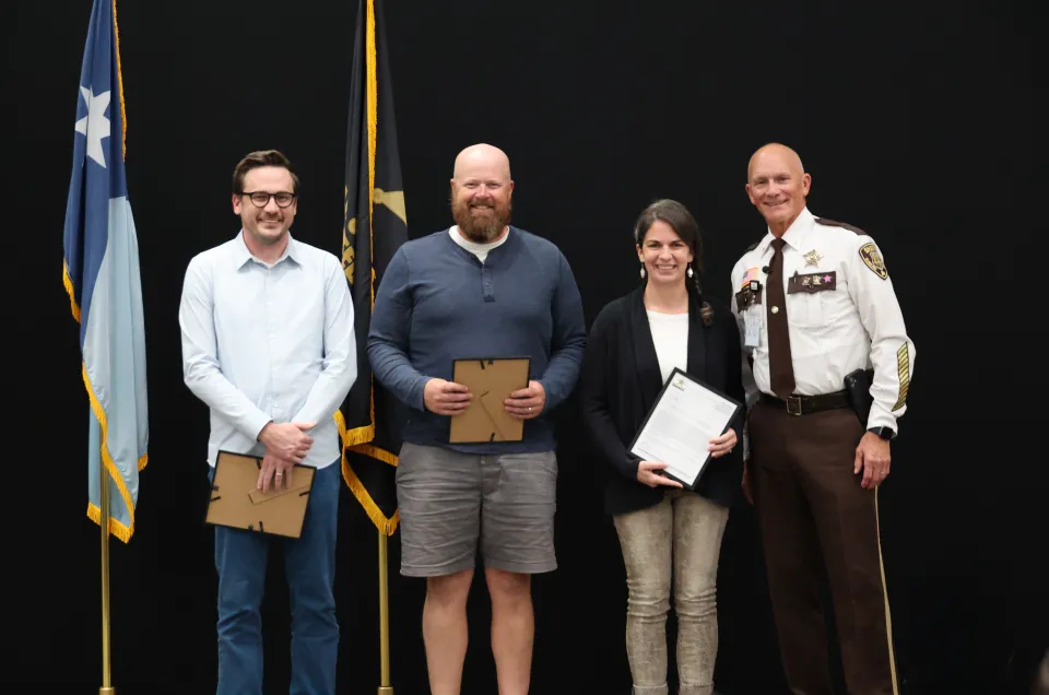Civilians stand on the stage after receiving their Letter of Recognition.