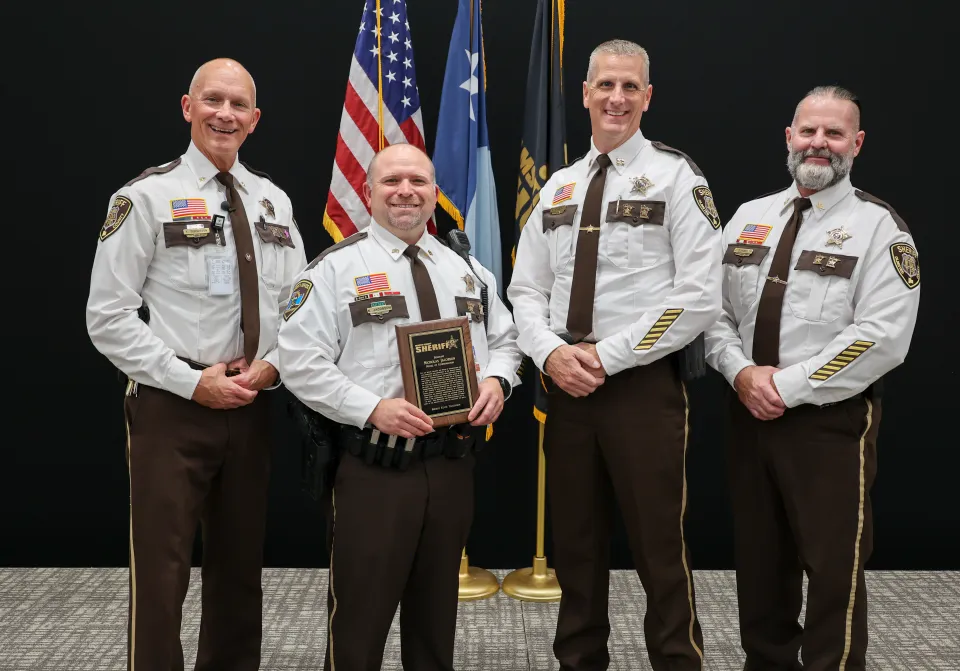 Members of the Olmsted County Sheriff's Office Command Staff stand with Sergeant Nick Jacobson after he received his award.