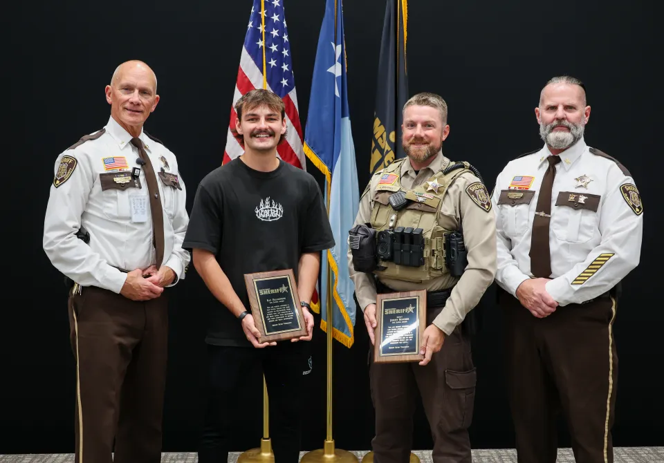 Members of the sheriff's office stand with a civilian award recipient after the awards program.  