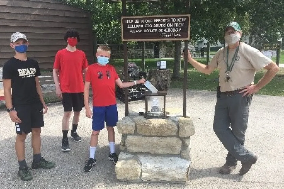 Presenting the check to Oxbow Park Manager, Lonnie, are Team R.E.D. members (left to right) Tristan, Marvin, and Jonas