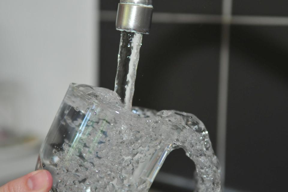 A glass being filled with water from the faucet