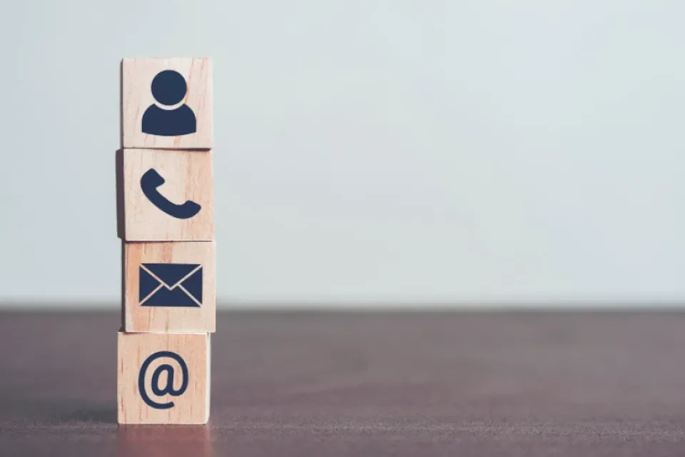 wooden blocks stacked up on each other with symbols of contacts. 