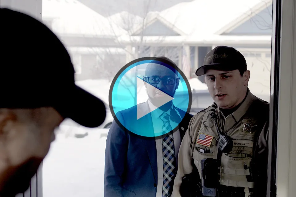 Image of officer and outreach specialist at door