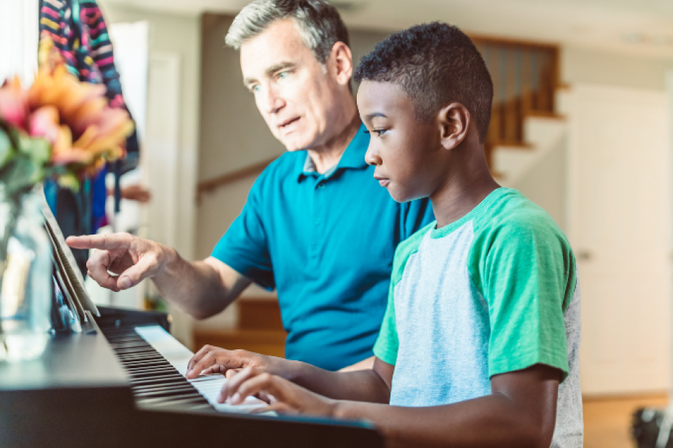 Foster dad teaching foster son how to play piano 