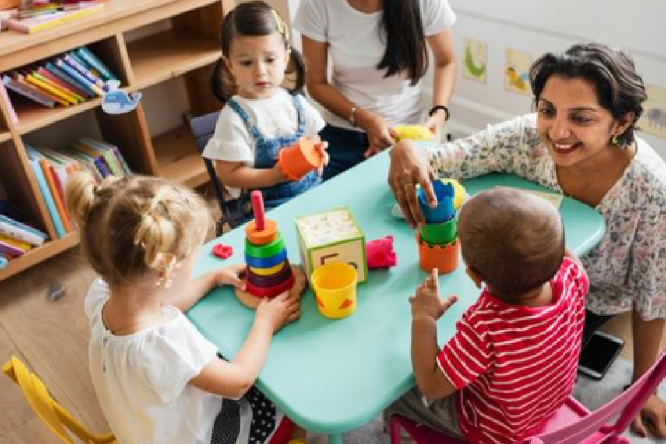 daycare women playing blocks with children