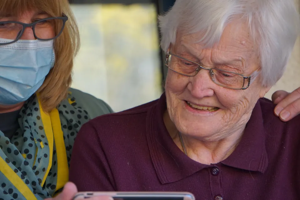 a doctor and an older woman looking at a phone