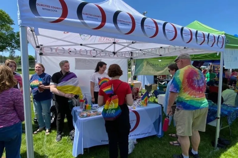 group of people standing around a tent at an event