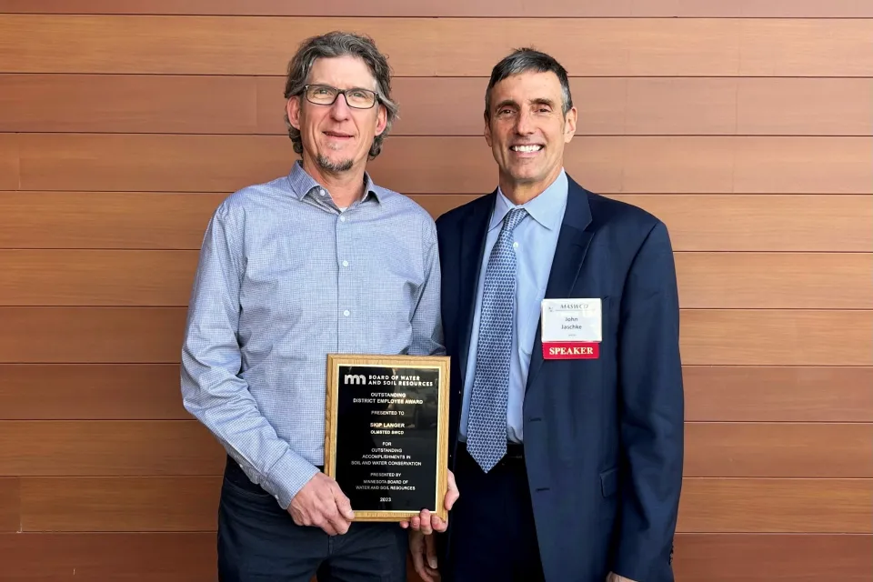 Olmsted County SWCD District Manager Skip Langer holding the 2023 Outstanding SCWD Employee Award. He is pictured with BWSR Executive Director John Jaschke