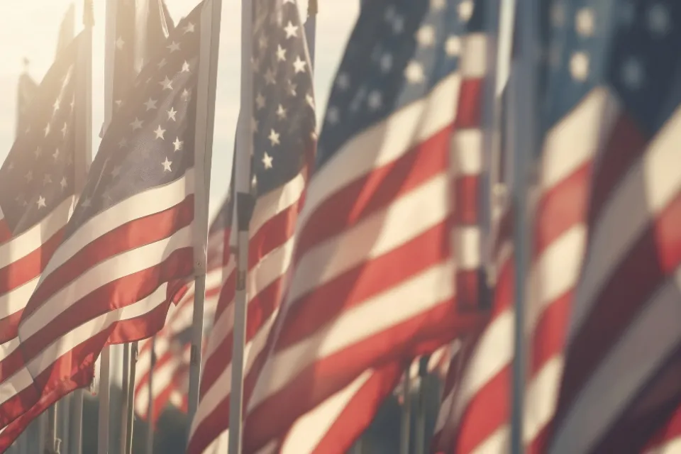 The sun shining on a row of American flags.