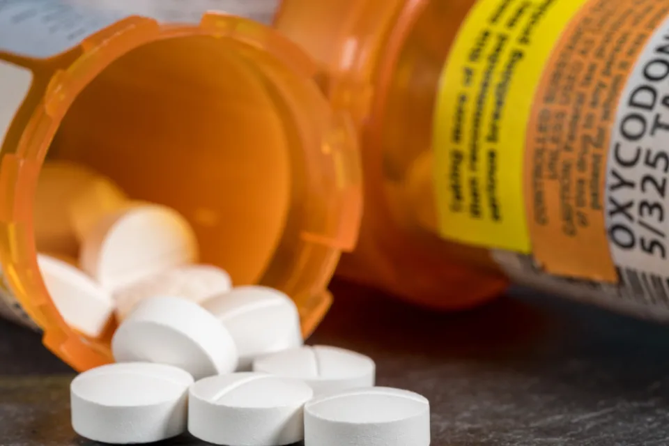 Pill bottle of prescription pills spilling out.