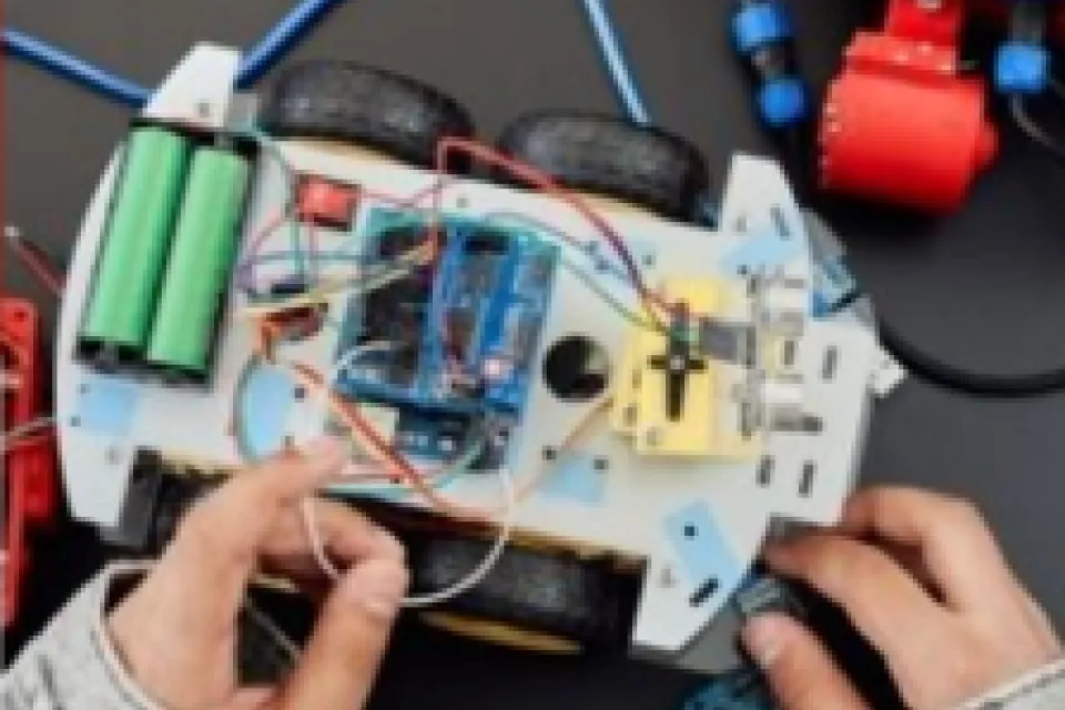 Hands working on fixing an electronic toy car
