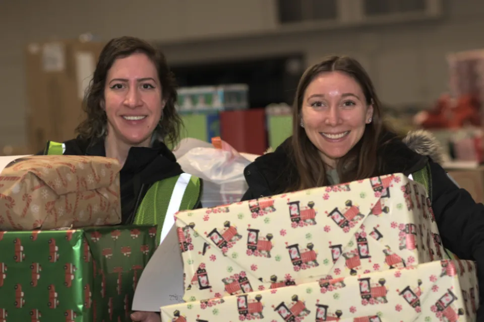 Employees holding Christmas presents