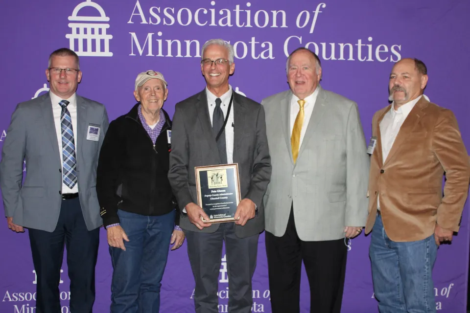 Pete Giesen with AMC Award alongside Travis Gransee and some county commissioners