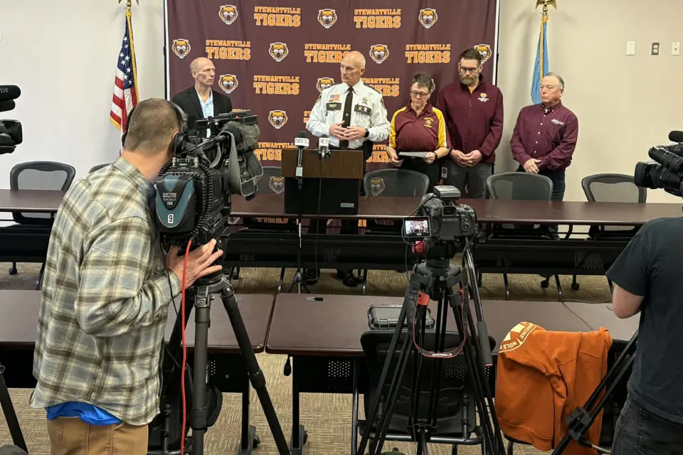 Members of the Sheriff's Office and Stewartville Schools stand in front of media at a press conference