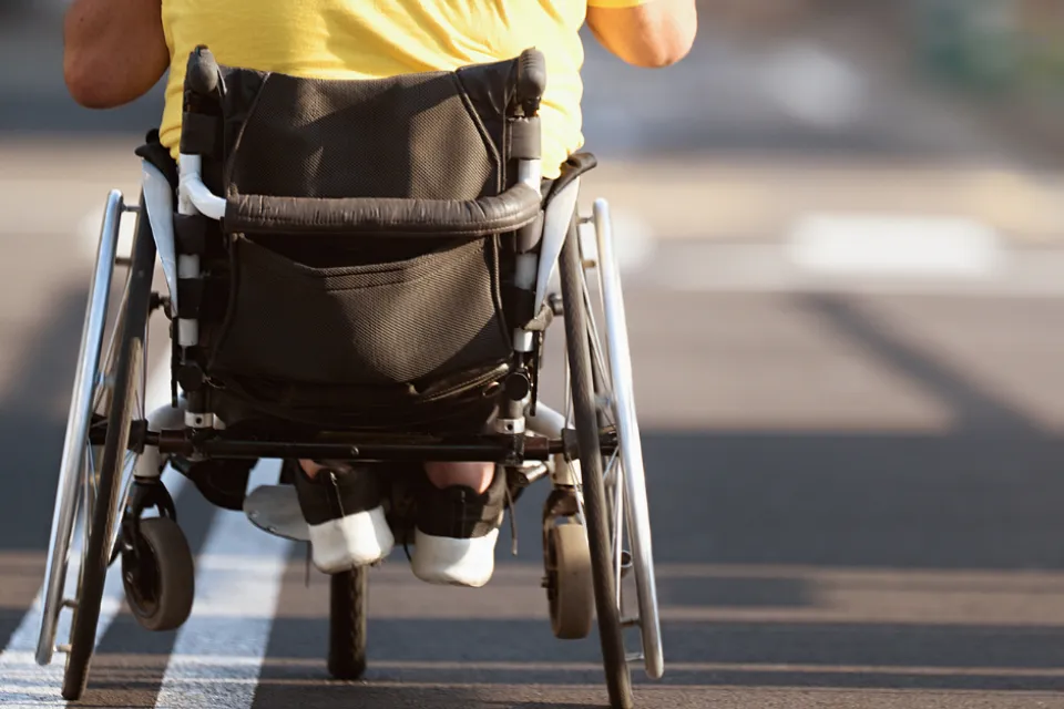 Person using wheelchair on sidewalk