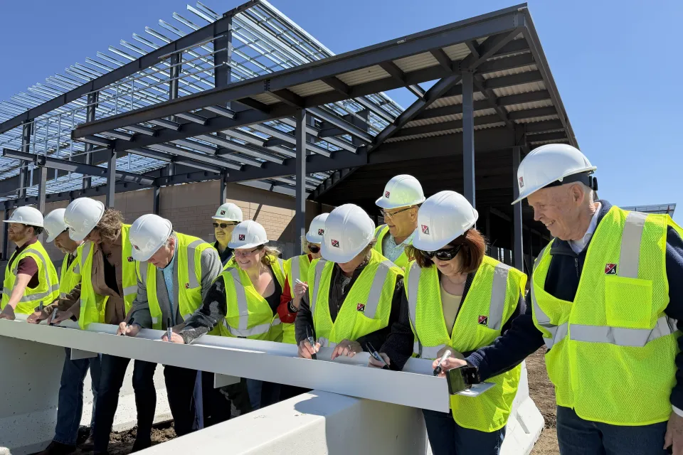 Olmsted County board and local legislator signing beam