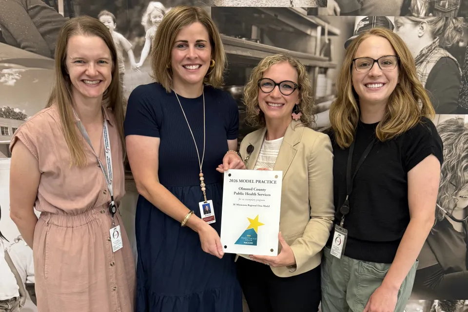 Four people holding an award. From right to left:  Megan Schroeder, Public Health Strategist Meaghan Sherden, Associate Director Tina Jordahl, Program Manager Jenny Passer, Epidemiologist 
