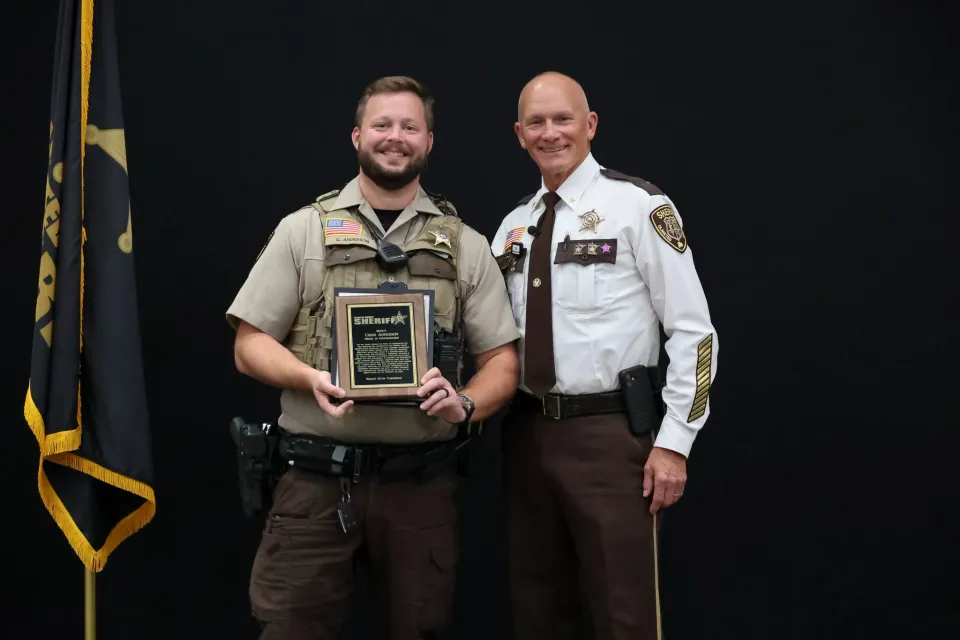 Deputy stands with Sheriff Torgerson after receiving an award.